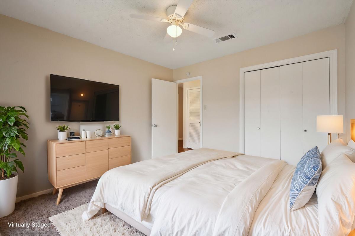 Carpeted primary bedroom at Bay Colony Apartments